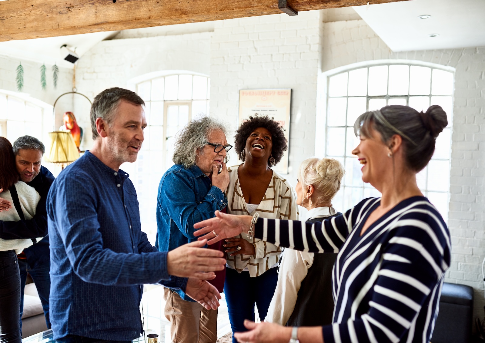 Mature friends greeting each other at social gathering